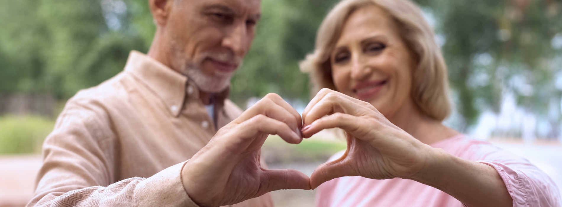 Two people making a heart shape with their hands.